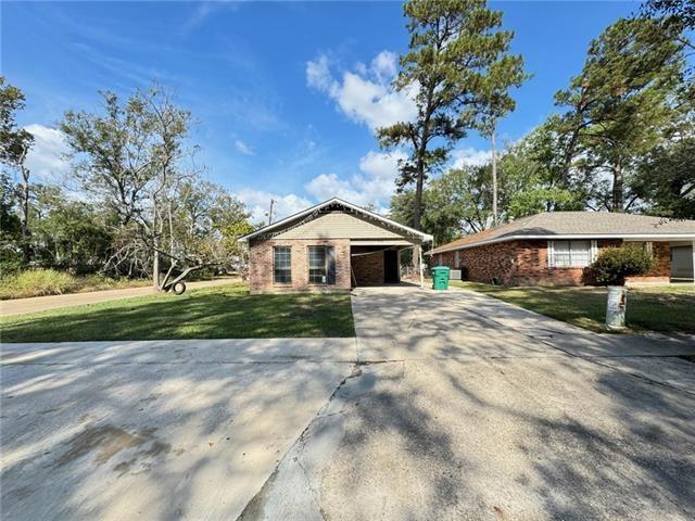 ranch-style home with a front yard and a carport