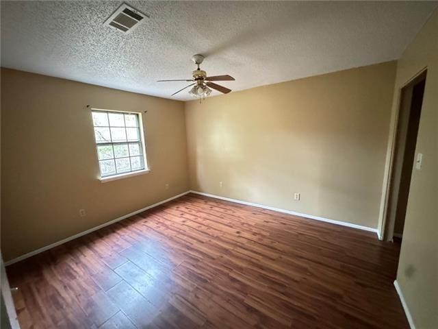 spare room with ceiling fan, dark wood-type flooring, and a textured ceiling