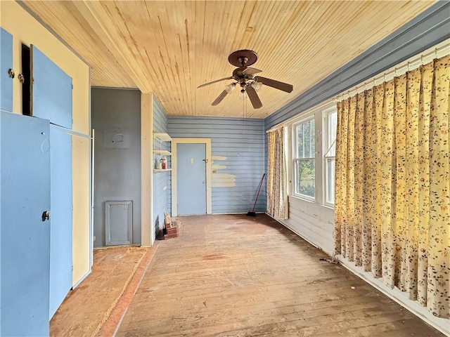 interior space with wood-type flooring and wooden walls