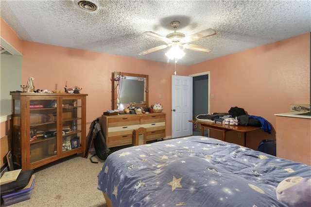 bedroom with ceiling fan, carpet, and a textured ceiling