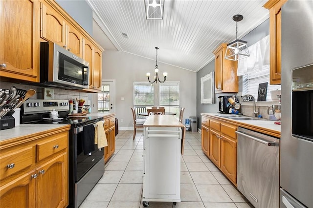 kitchen featuring decorative light fixtures, stainless steel appliances, sink, a chandelier, and vaulted ceiling