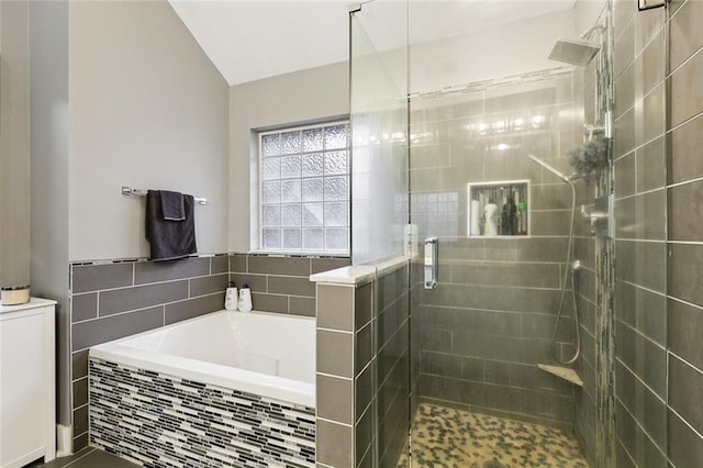 bathroom featuring separate shower and tub and lofted ceiling