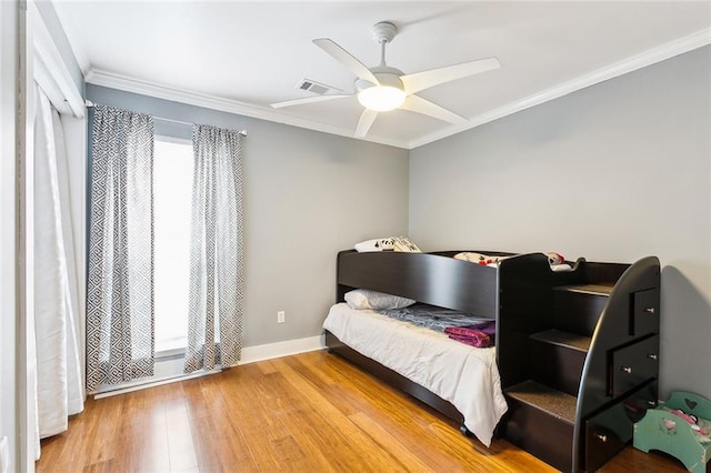 bedroom featuring ceiling fan, hardwood / wood-style floors, and crown molding