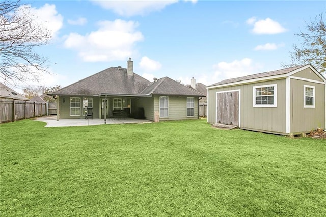 rear view of house with a patio area, a lawn, and a shed