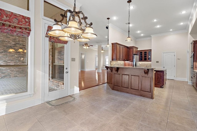 kitchen featuring backsplash, high end fridge, hanging light fixtures, ornamental molding, and ceiling fan with notable chandelier