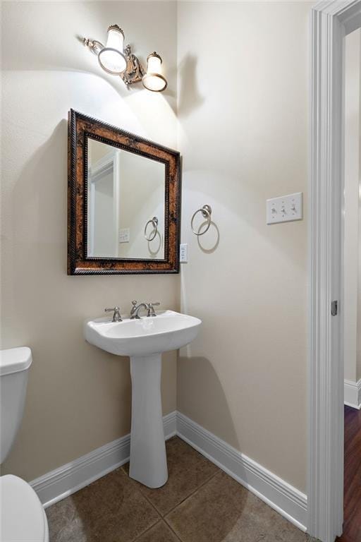 bathroom featuring sink, toilet, and tile patterned flooring