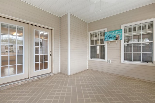 unfurnished sunroom with ceiling fan and french doors