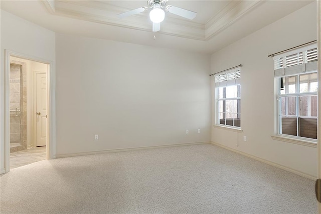 carpeted spare room featuring ceiling fan, crown molding, and a raised ceiling