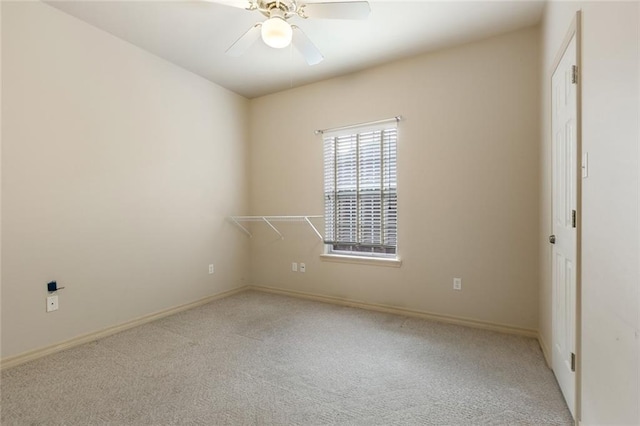 carpeted spare room featuring ceiling fan