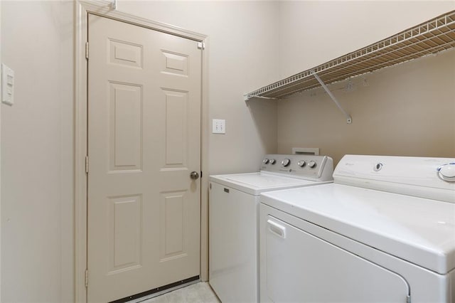 clothes washing area with separate washer and dryer