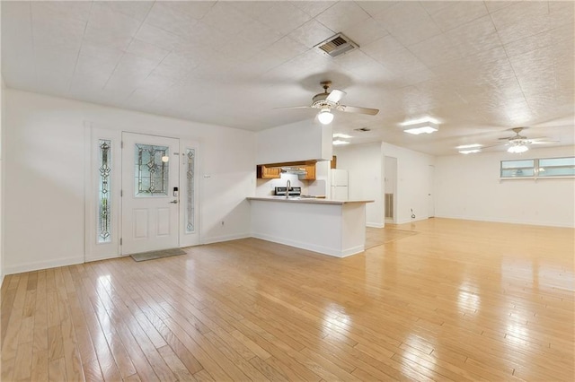 unfurnished living room featuring ceiling fan and light wood-type flooring