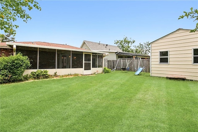 rear view of property featuring a sunroom and a lawn