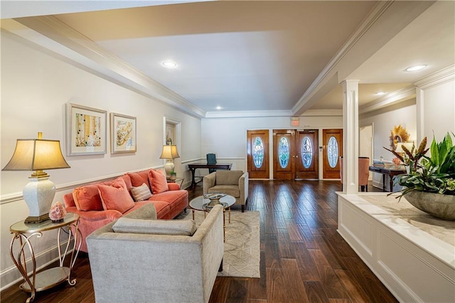 living room featuring ornate columns, dark hardwood / wood-style flooring, and crown molding