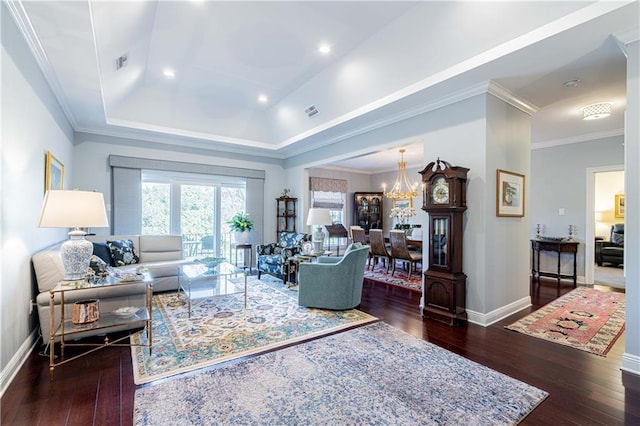 living room with dark hardwood / wood-style floors, crown molding, a raised ceiling, and an inviting chandelier