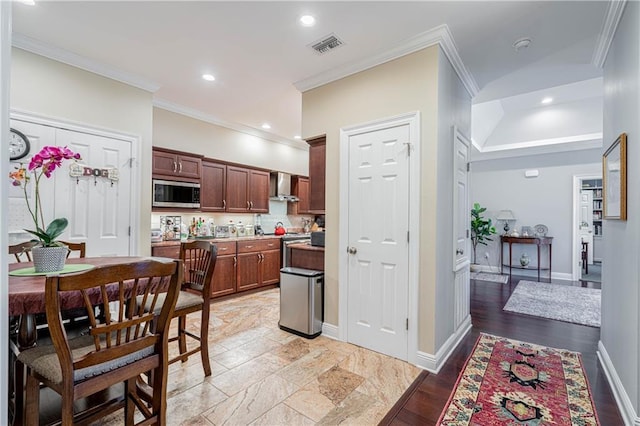 kitchen featuring lofted ceiling, ornamental molding, decorative backsplash, and wall chimney range hood