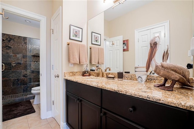 bathroom with a shower, tile patterned floors, vanity, and toilet