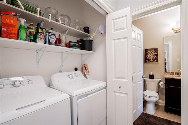 clothes washing area featuring washing machine and dryer and light tile patterned flooring