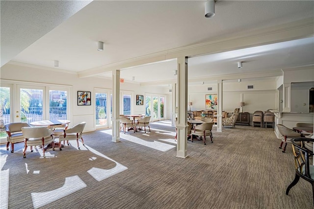 carpeted dining room featuring crown molding and french doors