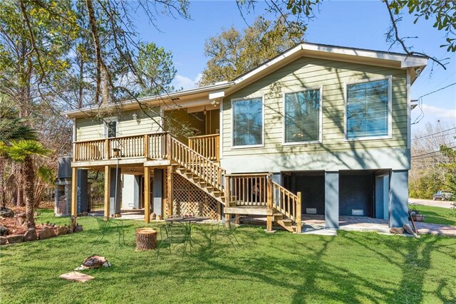 rear view of house featuring a patio area, a wooden deck, and a lawn