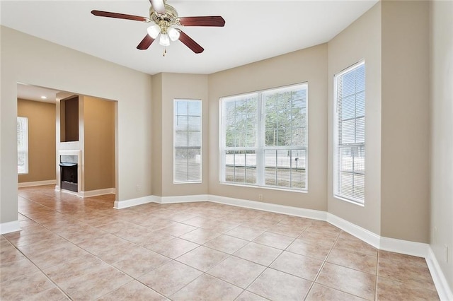 tiled spare room featuring ceiling fan