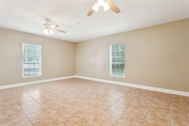 tiled spare room featuring ceiling fan and a wealth of natural light