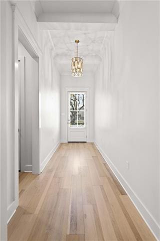 hall with an inviting chandelier and light hardwood / wood-style floors