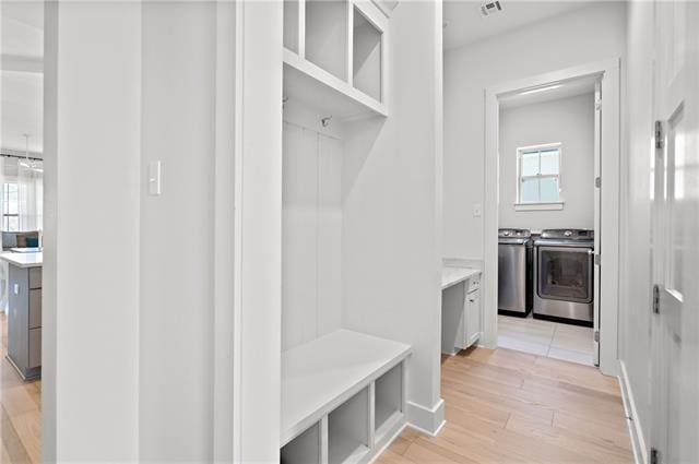 mudroom featuring light wood-type flooring and independent washer and dryer