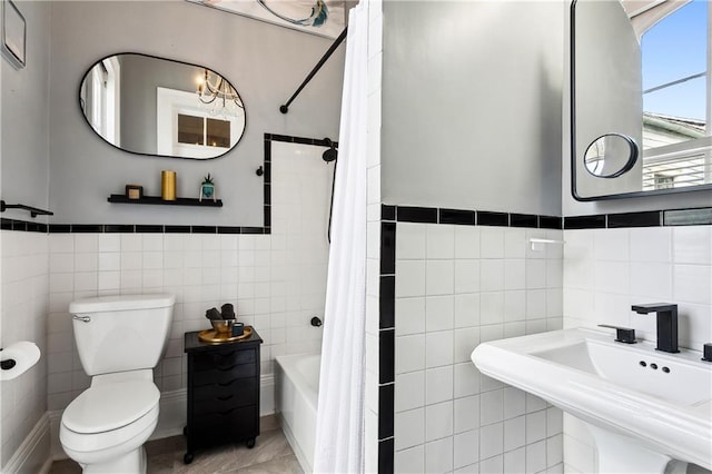 full bathroom with tile patterned floors, tile walls, sink, toilet, and shower / tub combo with curtain