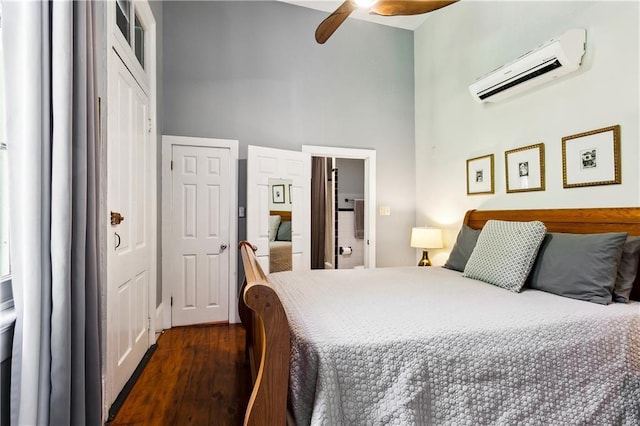 bedroom featuring multiple closets, ceiling fan, a high ceiling, dark hardwood / wood-style floors, and an AC wall unit