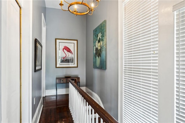 hallway featuring an inviting chandelier and dark wood-type flooring