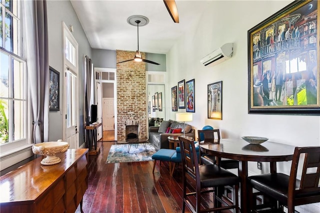 dining room with a wall mounted air conditioner, ceiling fan, and dark hardwood / wood-style flooring