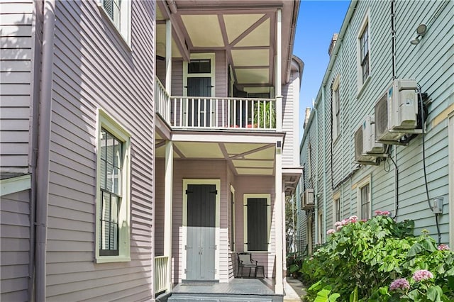 view of exterior entry featuring a balcony