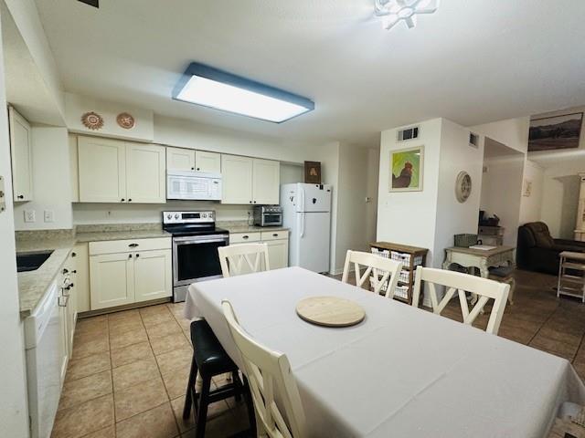 dining area with sink and light tile patterned flooring