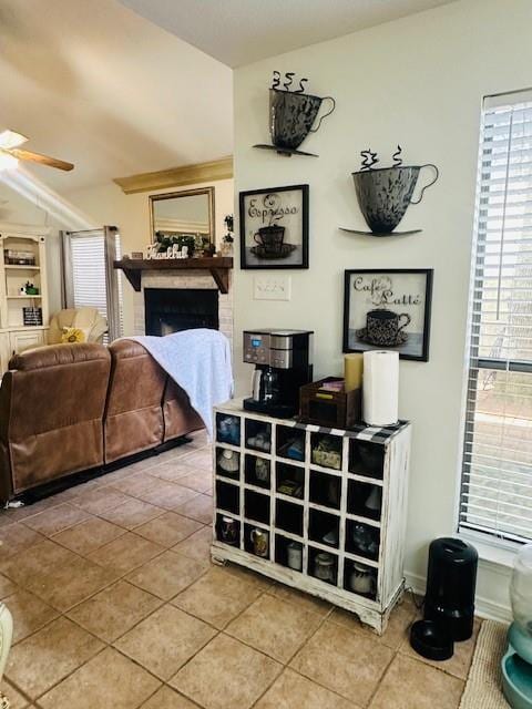 bedroom featuring ceiling fan, a fireplace, and tile patterned floors