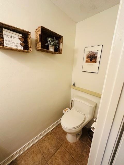 bathroom with toilet and tile patterned flooring