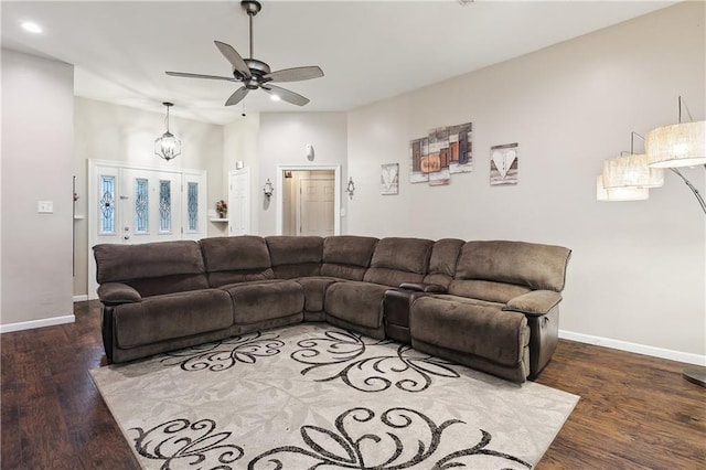 living room featuring ceiling fan and dark wood-type flooring