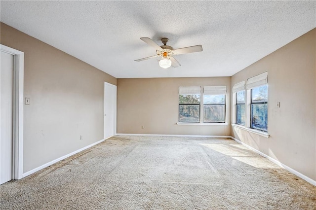 carpeted spare room with ceiling fan and a textured ceiling