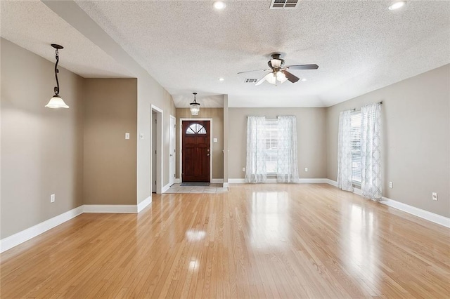 foyer featuring ceiling fan, light wood-type flooring, and a textured ceiling