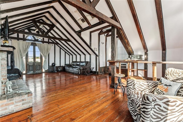 living room with lofted ceiling with beams, a fireplace, and hardwood / wood-style floors