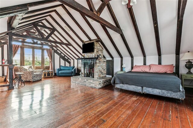 bedroom featuring high vaulted ceiling, hardwood / wood-style floors, beamed ceiling, and a fireplace