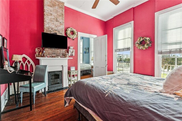 bedroom with ceiling fan, ornamental molding, a fireplace, and dark hardwood / wood-style floors