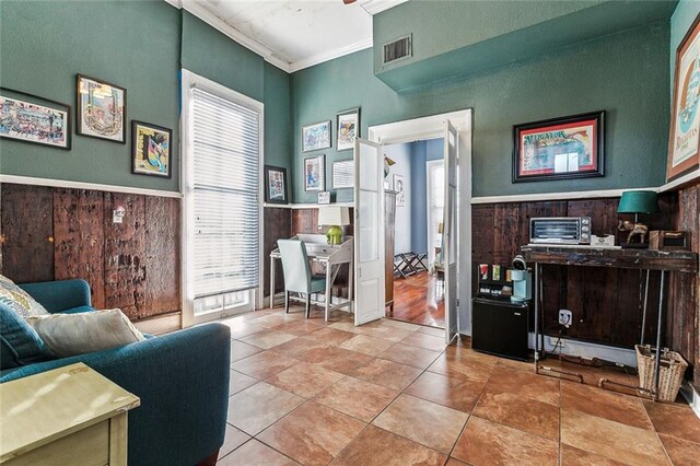 tiled office featuring wood walls and ornamental molding