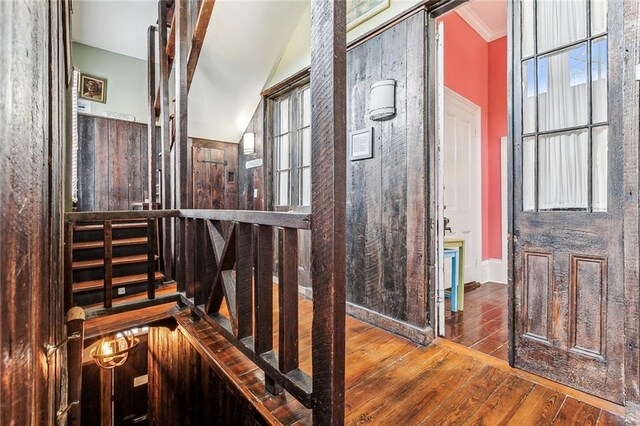 interior space featuring a healthy amount of sunlight, vaulted ceiling, crown molding, and hardwood / wood-style floors