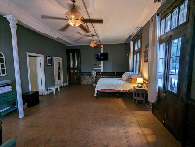 tiled bedroom featuring ceiling fan and ornate columns