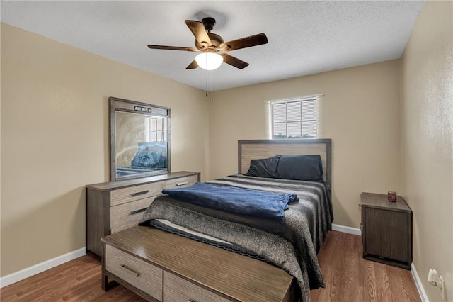 bedroom featuring ceiling fan, dark wood-type flooring, and a textured ceiling