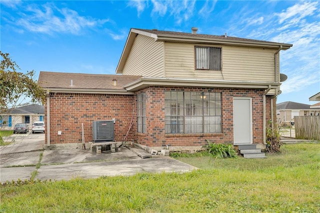 back of property featuring central AC unit, a lawn, and a patio