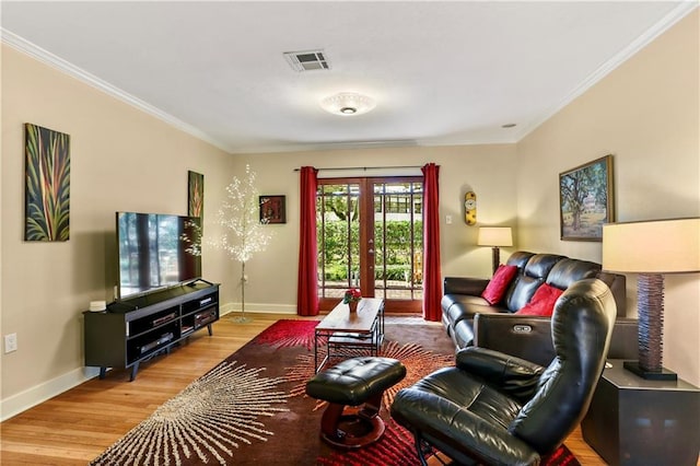 living room featuring hardwood / wood-style floors, crown molding, and french doors