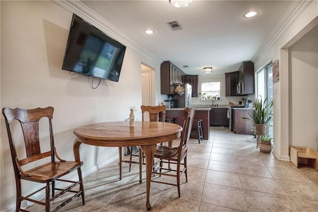 tiled dining space featuring crown molding