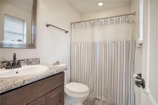 bathroom with toilet, vanity, and curtained shower