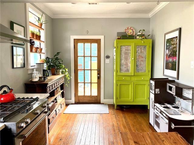 entryway with ornamental molding and light wood-type flooring